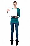 Full Length Shot Of Smiling Girl Holding Laptop Stock Photo