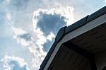 Gabled Roof Under A Cloudy Sky Stock Photo