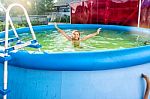 Girl Bathing In A Pool In The Yard Stock Photo