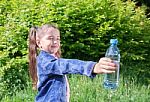 Girl Giving A Plastic Bottle With Water Stock Photo