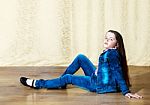 Girl In A Blue Denim Suit Sitting In The Studio Stock Photo