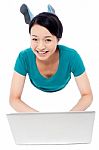 Girl Lying On The Studio Floor And Using Laptop Stock Photo