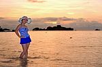 Girl On The Beach At Sunrise Over The Sea Stock Photo