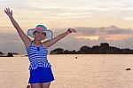 Girl On The Beach At Sunrise Over The Sea Stock Photo