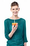 Girl Sipping Orange Juice Through Straw Stock Photo