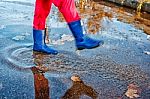 Girl Standing In A Puddle Of Water Splashes Stock Photo