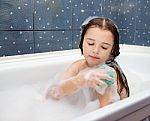 Girl Washes Her Hand Sitting In The Bath Stock Photo