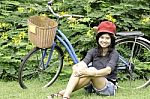 Girl With A Bicycle Rests On A Grass Stock Photo