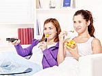 Girls Watching Tv And Eating Fruit Stock Photo