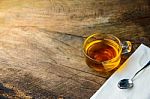 Glass Cup Of Tea And Spoons On Old Wooden Table Stock Photo