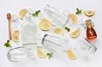 Glasses And Bottle For Drinks With Lemon Slices, Mint And Honey Stock Photo