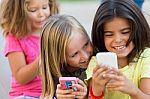 Group Of Childrens Chatting With Smart Phones In The Park Stock Photo