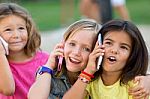 Group Of Childrens Using Mobile Phones In The Park Stock Photo