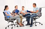 Group Of Confident Business Partners Discussing Paper Meeting Stock Photo