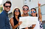 Group Of Friends Use Their Map In The Street Stock Photo