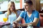 Group Of Friends Using Mobile Phone In Cafe Stock Photo