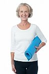 Gym Instructor Holding Blue Exercise Mat Stock Photo
