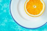 Half Of Orange On The White Plate On The Cyan Background Horizontal Stock Photo