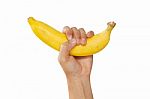 Hand Holds A Banana, Is Isolated On A White Background Stock Photo