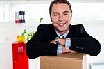 Handsome Businessman Leaning On Packed Carton Stock Photo