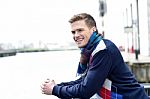 Handsome Man Leaning On Railing At River Stock Photo