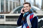 Handsome Man Using Mobile At Bridge Railing Stock Photo