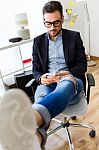 Handsome Young Man Using His Mobile Phone In The Office Stock Photo