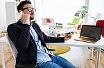 Handsome Young Man Using His Mobile Phone In The Office Stock Photo