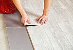 Handyman's Hands Laying Down Laminate Flooring Boards Stock Photo