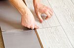 Handyman's Hands Laying Down Laminate Flooring Boards Stock Photo