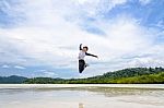 Happy Asian Woman Jumping Fun On The Beach Stock Photo