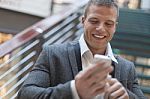 Happy Businessman With Smartphone In Business Building Stock Photo