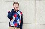 Happy Man Leaning Against Wall With Cell Phone Stock Photo