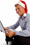 Happy Man With Christmas Hat And Laptop Stock Photo