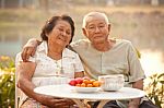 Happy Senior Couple Sitting Outdoors Stock Photo