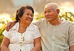 Happy Senior Couple Sitting Outdoors Stock Photo