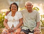 Happy Senior Couple Sitting Outdoors Stock Photo