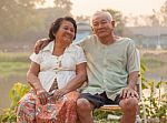 Happy Senior Couple Sitting Outdoors Stock Photo