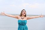 Happy Woman With Open Arms Looking At The Sky Stock Photo