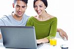 Happy Young Couple Browsing Internet At Home Stock Photo