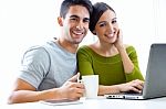 Happy Young Couple Browsing Internet At Home Stock Photo