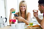 Happy Young Couple Enjoying Breakfast In The Kitchen Stock Photo