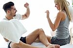 Happy Young Couple Playing With Pillows In The Sofa Stock Photo