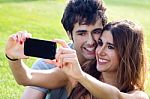 Happy Young Couple With Smartphone At The Park Stock Photo