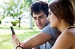 Happy Young Couple With Smartphone At The Park Stock Photo