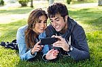 Happy Young Couple With Smartphone At The Park Stock Photo