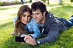 Happy Young Couple With Smartphone At The Park Stock Photo