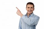 Happy Young Man Pointing At Something Stock Photo