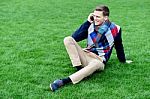 Happy Young Man Using Mobile Phone On Park Stock Photo