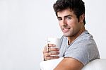 Happy Young Man With A Steamy Cup Of Coffee At Home Stock Photo